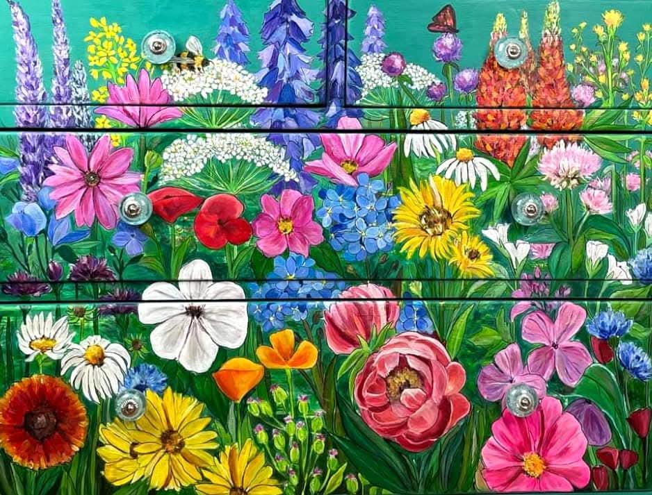 Close‑up of hand‑painted floral artwork on a vintage dresser.